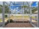 Enclosed lanai with brick flooring offering views of the fenced backyard and lush landscaping at 5238 Aqua Breeze Dr, Bradenton, FL 34208