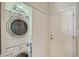 Laundry room features stacked washer and dryer with storage shelf above, next to a door with white trim at 5238 Aqua Breeze Dr, Bradenton, FL 34208