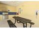 Community outdoor kitchen with stainless steel grill, picnic table, and emergency phone access at 5238 Aqua Breeze Dr, Bradenton, FL 34208