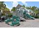A colorful community playground offers slides and climbing features, surrounded by palm trees and lush greenery for outdoor fun at 5238 Aqua Breeze Dr, Bradenton, FL 34208