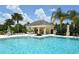 A luxurious community pool with a covered cabana, grilling area, and lounge seating, perfect for poolside relaxation at 5238 Aqua Breeze Dr, Bradenton, FL 34208