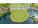 The Meadows Country Club golf course's island green with a wood bridge and practice range with golf carts at 5269 Wedgewood Ln # 36, Sarasota, FL 34235