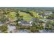 Aerial view showcasing a golf course community with manicured greens, water features and clubhouse at 5269 Wedgewood Ln # 36, Sarasota, FL 34235
