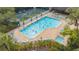 Aerial view of the community pool featuring a spacious deck, lounge chairs, a spa, and lush landscaping at 5269 Wedgewood Ln # 36, Sarasota, FL 34235