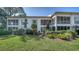 Condo exterior featuring screened balconies, lush greenery, and a well-maintained lawn at 5269 Wedgewood Ln # 36, Sarasota, FL 34235