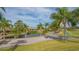 Beautiful golf course and waterway view of the club house lined with palm trees and golf carts at 5269 Wedgewood Ln # 36, Sarasota, FL 34235