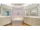 Elegant bathroom featuring double sinks, a large soaking tub, and recessed lighting at 5283 Descanso Ct # 101B18, Sarasota, FL 34238