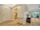 Inviting entryway with light wood floors, leading to an open kitchen and a bright living space with lake views at 5283 Descanso Ct # 101B18, Sarasota, FL 34238