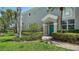 Charming home entrance with a striking turquoise door, complemented by manicured landscaping and a paver walkway at 5283 Descanso Ct # 101B18, Sarasota, FL 34238