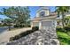 Spacious three-car garage with a paver driveway, set against a backdrop of well-maintained landscaping and trees at 5283 Descanso Ct # 101B18, Sarasota, FL 34238