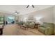 Cozy living room featuring comfortable green seating, wood floors, and sliding glass doors to the lanai at 5283 Descanso Ct # 101B18, Sarasota, FL 34238
