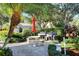 Outdoor patio with two grills, table, chairs surrounded by manicured landscaping and trees at 5283 Descanso Ct # 101B18, Sarasota, FL 34238