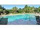 Inviting community pool with sparkling water, lounge chairs, and lush tropical landscaping at 5283 Descanso Ct # 101B18, Sarasota, FL 34238