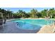 Outdoor pool surrounded by plenty of seating and palm trees at 5283 Descanso Ct # 101B18, Sarasota, FL 34238