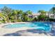 Inviting pool area with lounge chairs, umbrellas, and tropical landscaping and trees at 5283 Descanso Ct # 101B18, Sarasota, FL 34238