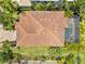 Aerial view of a home with a clay tile roof, screened in pool and verdant landscaping at 5503 Title Row Dr, Bradenton, FL 34210