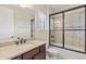 Modern bathroom with a dark wood vanity, framed mirror, and a glass-enclosed shower at 5503 Title Row Dr, Bradenton, FL 34210