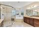 A bathroom featuring a glass shower, soaking tub, and vanity with dark wood cabinets at 5503 Title Row Dr, Bradenton, FL 34210