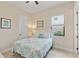 Bright bedroom featuring tile floors, a comfortable bed, a ceiling fan, and natural light from the window at 5503 Title Row Dr, Bradenton, FL 34210