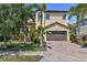 Two-story home boasts lush landscaping, a brick driveway, and a neutral-toned exterior with a two-car garage at 5503 Title Row Dr, Bradenton, FL 34210