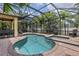 A beautiful screened-in pool with brick patio, spa and lounging area at 5503 Title Row Dr, Bradenton, FL 34210