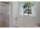 Bathroom featuring a soaking tub with a shower and a large window providing ample natural light at 5782 Sandy Pointe Dr, Sarasota, FL 34233