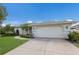 Well-maintained home with a lush green lawn, a concrete driveway, and a two-car garage at 5782 Sandy Pointe Dr, Sarasota, FL 34233