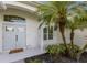 Covered front entryway with custom double doors, a manicured garden bed, and a tile entryway at 5782 Sandy Pointe Dr, Sarasota, FL 34233