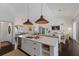 Open-concept kitchen featuring a marble island, stainless steel appliances, and woven pendant lighting at 5782 Sandy Pointe Dr, Sarasota, FL 34233