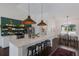 Kitchen island with seating and statement lighting at 5782 Sandy Pointe Dr, Sarasota, FL 34233