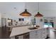 Bright, modern kitchen with a marble island, stainless steel sink, and open access to the living area and pool at 5782 Sandy Pointe Dr, Sarasota, FL 34233