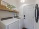 Well-lit laundry room with washer, dryer, modern light fixture and decor at 5782 Sandy Pointe Dr, Sarasota, FL 34233