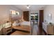 Cozy main bedroom with a four-poster bed, neutral tones, and sliding glass doors overlooking the pool at 5782 Sandy Pointe Dr, Sarasota, FL 34233