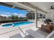 Screened-in pool with attached hot tub, lounge chairs, and seating at 5782 Sandy Pointe Dr, Sarasota, FL 34233