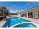 Screened-in pool with attached hot tub and string lights on a spacious patio at 5782 Sandy Pointe Dr, Sarasota, FL 34233
