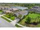 Lovely home featuring meticulous landscaping, a well-maintained lawn, and a tranquil view of the adjacent lake at 5978 Anise Dr, Sarasota, FL 34238