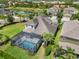 Aerial view of a home with a screened-in pool, manicured lawn, and lush landscaping at 5978 Anise Dr, Sarasota, FL 34238