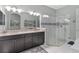 A Primary bathroom features double sinks, dark cabinets, walk-in shower with white and gray tile at 5978 Anise Dr, Sarasota, FL 34238