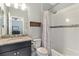 Well-lit bathroom featuring a vanity with granite countertop, and a shower/tub combo with patterned curtain at 5978 Anise Dr, Sarasota, FL 34238