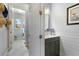 A half bath showcases a vanity with gray cabinets and a view into the laundry room at 5978 Anise Dr, Sarasota, FL 34238
