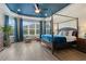 A luxurious bedroom features a canopy bed, blue ceiling and curtains, with a view of the backyard at 5978 Anise Dr, Sarasota, FL 34238