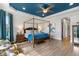 A Primary suite featuring a king bed, blue accent ceiling, and a large doorway to the Primary bath at 5978 Anise Dr, Sarasota, FL 34238