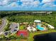 Bird's eye view featuring a community pool, splash park, and various recreational facilities amidst lush greenery at 5978 Anise Dr, Sarasota, FL 34238