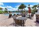 Community pool featuring chairs, tables, and lounge seating surrounded by palm trees under a sunny, partly cloudy sky at 5978 Anise Dr, Sarasota, FL 34238