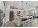 Modern white kitchen featuring a large island, stainless steel appliances, and ample counter space at 5978 Anise Dr, Sarasota, FL 34238