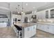 Bright kitchen featuring white cabinetry, stainless steel appliances, large island with seating and ample counter space at 5978 Anise Dr, Sarasota, FL 34238