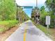 Paved Legacy Trail surrounded by lush greenery and palm trees with signage for safety and directions at 5978 Anise Dr, Sarasota, FL 34238