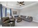Inviting living room with a comfortable sectional sofa, neutral carpet, and a large window with curtains at 5978 Anise Dr, Sarasota, FL 34238