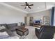Spacious living room featuring a large sectional sofa, tray ceiling with fan, and entertainment center at 5978 Anise Dr, Sarasota, FL 34238