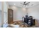 A home office features a dark desk and decorative hutch, complemented by a ceiling fan and natural light at 5978 Anise Dr, Sarasota, FL 34238